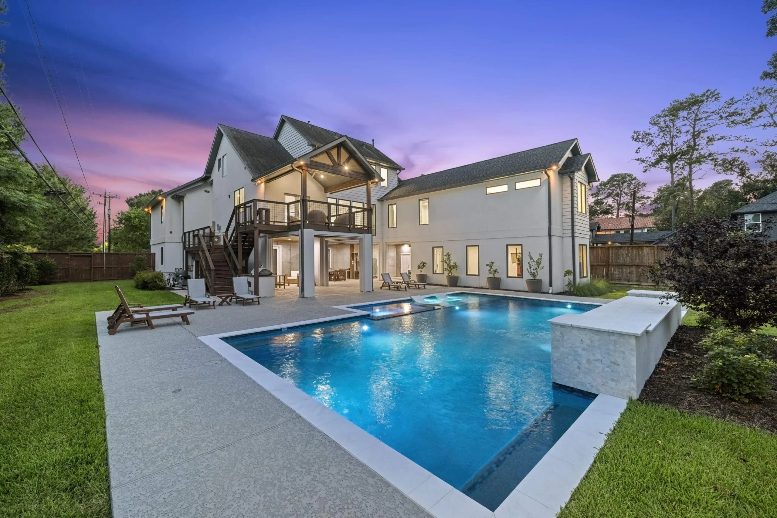Custom pool and spa at twilight behind a Houston-area home built by Costa Maya Pools