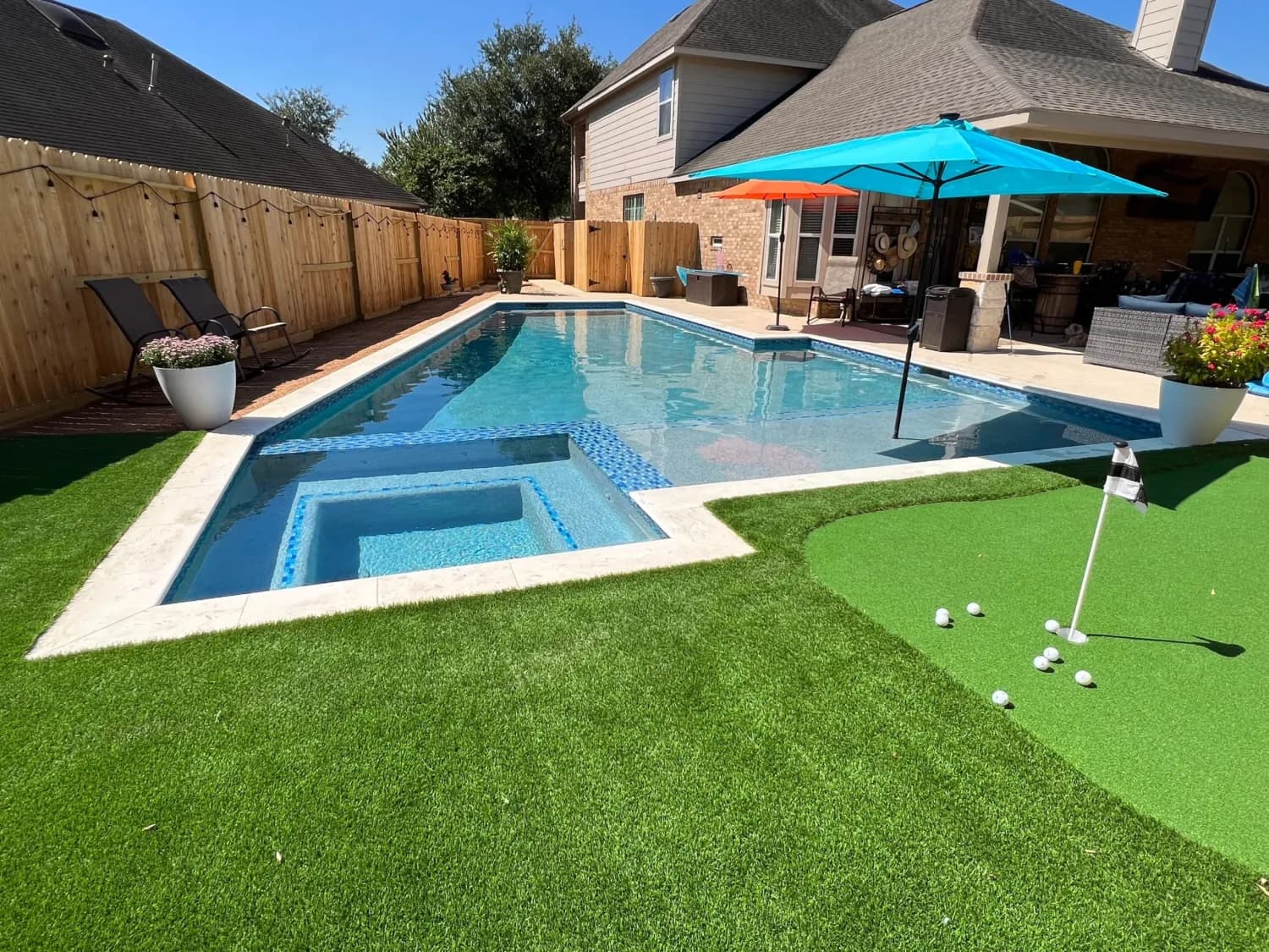 Backyard pool with spa, turf and putting green built by Costa Maya Pools